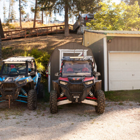 Rider driving an ATV on a dirt trail near Waitts Lake with forested terrain