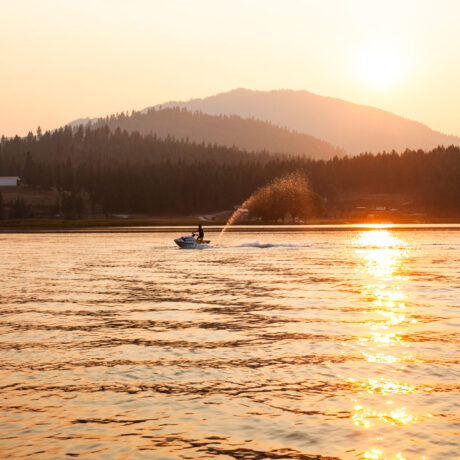 Jet ski rider speeding across Waitts Lake with mountain backdrop